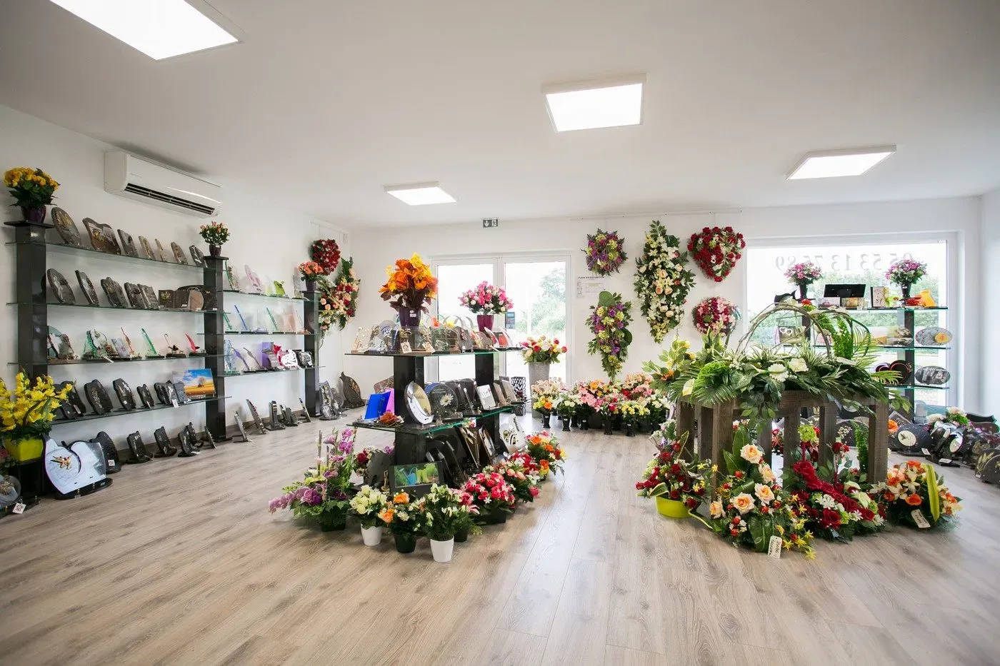 Magasin funéraire exposant des fleurs, urnes et plaques commémoratives